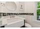 Stylish bathroom with a modern sink, decorative backsplash, and a round mirror complementing the contemporary design at 1667 Willow Way, Woodstock, GA 30188