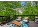 Outdoor deck area features an umbrella and two chairs surrounded by lush greenery at 1667 Willow Way, Woodstock, GA 30188