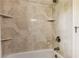 Bathroom shower boasts neutral tile surround, built-in shelves, and bronze fixtures at 1667 Willow Way, Woodstock, GA 30188