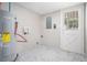 Utility room with modern water heater, gray tiled floors, and access door for convenient maintenance and outdoor access at 2403 Tiffany Pl, Decatur, GA 30035