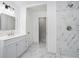 Modern bathroom featuring marble tile, double sink vanity, and a shower at 2403 Tiffany Pl, Decatur, GA 30035