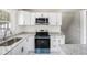 Modern kitchen featuring stainless steel appliances, granite countertops, and sleek white cabinets for ample storage at 2403 Tiffany Pl, Decatur, GA 30035