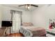 Well-lit bedroom with hardwood floors, ceiling fan and window with blinds and curtains at 338 Saratoga Pl, Riverdale, GA 30296