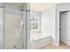 Bathroom featuring a glass shower, garden tub, and lots of natural light at 750 Ambrose Ln, Atlanta, GA 30349