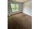 Bedroom with a window, carpet flooring, and neutral colored walls at 750 Ambrose Ln, Atlanta, GA 30349