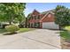 Charming two-story red brick home with a spacious driveway, attached garage, and well-manicured lawn at 750 Ambrose Ln, Atlanta, GA 30349