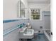 Vintage bathroom features blue tile, a window for natural light, and a classic sink and bathtub at 1102 Rogeretta Ne Dr, Atlanta, GA 30329