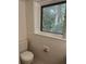Cozy bathroom featuring a toilet and a window that overlooks a wooded area at 1102 Rogeretta Ne Dr, Atlanta, GA 30329