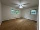 Bright bedroom featuring a ceiling fan and natural light from two windows overlooking a wooded area at 1102 Rogeretta Ne Dr, Atlanta, GA 30329