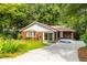 Charming brick home featuring a well-manicured lawn, mature trees, and a concrete driveway at 1102 Rogeretta Ne Dr, Atlanta, GA 30329