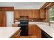 Close up of kitchen featuring oak cabinets, black gas range and white countertops at 1102 Rogeretta Ne Dr, Atlanta, GA 30329