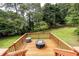 Wooden back deck featuring a fire pit with green yard and tree view at 4047 Dunwoody Club Dr, Dunwoody, GA 30350