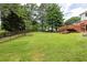 Expansive backyard featuring a well-maintained lawn, mature trees, and a wooden deck, perfect for outdoor enjoyment at 4047 Dunwoody Club Dr, Dunwoody, GA 30350