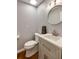 Stylish powder room with modern vanity, round mirror, and hardwood style floors at 4047 Dunwoody Club Dr, Dunwoody, GA 30350