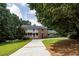 Charming two-story brick home with a welcoming front porch, a well-manicured lawn, and a long driveway at 4047 Dunwoody Club Dr, Dunwoody, GA 30350