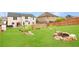 Large backyard featuring a grass lawn, fenced perimeter, and a rock fire pit area at 4455 Orchard Lake Dr, Cumming, GA 30028