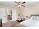 Comfortable bedroom featuring neutral tones, ceiling fan, plush carpet, and an ensuite bathroom for added convenience at 4455 Orchard Lake Dr, Cumming, GA 30028
