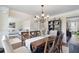 Spacious dining room with a wooden table set, a chandelier, and views into the living areas at 4455 Orchard Lake Dr, Cumming, GA 30028