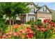 Well landscaped home exterior with a variety of flowers and healthy green lawn leading to the front door at 4455 Orchard Lake Dr, Cumming, GA 30028