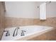 Soaking tub with chrome fixtures and tile surround at 827 Perennial Dr, Atlanta, GA 30328