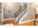 Bright foyer with hardwood floors, staircase with wooden railing, and neutral walls. Art adorns the walls at 827 Perennial Dr, Atlanta, GA 30328
