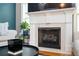 Close-up of a fireplace featuring a white mantle, black firebox, and stylish decor. Hardwood floors below at 827 Perennial Dr, Atlanta, GA 30328