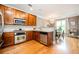 Open kitchen features wooden cabinets, stainless appliances, granite counters, and a breakfast nook at 827 Perennial Dr, Atlanta, GA 30328