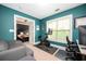 Spacious home office featuring teal walls, natural light, and an open doorway to the primary bedroom at 827 Perennial Dr, Atlanta, GA 30328
