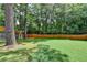 Backyard features a well-kept lawn, mature trees, and a wooden fence on the property line at 1169 Dorby Park Ne Dr, Brookhaven, GA 30319