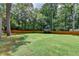 Large backyard with a well-maintained lawn, surrounded by a wooden privacy fence and mature trees at 1169 Dorby Park Ne Dr, Brookhaven, GA 30319