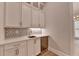 Wet bar area with white cabinets, stone countertop, and a beverage refrigerator at 1169 Dorby Park Ne Dr, Brookhaven, GA 30319