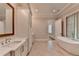 Bathroom with double sinks, modern vanity, soaking tub, updated fixtures, and tile flooring at 1169 Dorby Park Ne Dr, Brookhaven, GA 30319