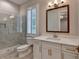 Bathroom features a glass shower, shuttered window, white vanity with gold hardware, and tile floors at 1169 Dorby Park Ne Dr, Brookhaven, GA 30319
