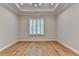 Bedroom features wood floors, neutral walls, tray ceiling with chandelier, and shuttered window at 1169 Dorby Park Ne Dr, Brookhaven, GA 30319