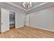 Bedroom features wood floors, neutral walls, white trim, tray ceiling with chandelier, and closet at 1169 Dorby Park Ne Dr, Brookhaven, GA 30319