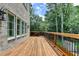 An expansive wood floored deck with railings adjacent to a brick home at 1169 Dorby Park Ne Dr, Brookhaven, GA 30319