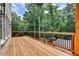 An expansive wood floored deck with railings adjacent to a brick home overlooking trees at 1169 Dorby Park Ne Dr, Brookhaven, GA 30319