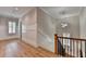 Second-floor hallway featuring wooden floors, wainscoting, modern lighting, and staircase with a wood banister at 1169 Dorby Park Ne Dr, Brookhaven, GA 30319