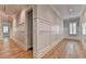 Bright hallway with beautiful white wainscoting, hardwood floors, and recessed lighting provides a luxurious feel at 1169 Dorby Park Ne Dr, Brookhaven, GA 30319