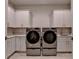 Well-equipped laundry room with modern washer and dryer, stylish cabinets, and countertop at 1169 Dorby Park Ne Dr, Brookhaven, GA 30319