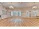 Open living room featuring hardwood floors, chandeliers, built-in shelving, and shuttered windows at 1169 Dorby Park Ne Dr, Brookhaven, GA 30319