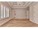 Spacious bedroom with tray ceilings, hardwood floors, a chandelier, and an ensuite bathroom with a soaking tub at 1169 Dorby Park Ne Dr, Brookhaven, GA 30319
