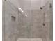 Modern tiled shower features a glass enclosure, shower head, and built-in shelving at 1169 Dorby Park Ne Dr, Brookhaven, GA 30319