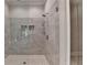 Modern tiled shower with glass door and built-in shelves for storage and organization at 1169 Dorby Park Ne Dr, Brookhaven, GA 30319