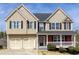 Charming two-story home with neutral siding, a two-car garage, and a welcoming front porch at 203 Overlook Ct, Dallas, GA 30157
