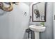 A stylish half-bathroom with a pedestal sink and decorative mirror at 364 Mossycup Dr, Fairburn, GA 30213