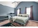 Spacious bedroom with blue walls, a plush bed, vaulted ceilings, and natural light, creating a cozy and peaceful retreat at 364 Mossycup Dr, Fairburn, GA 30213