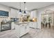 Bright kitchen with white cabinetry, an island, and an open view to the dining area at 364 Mossycup Dr, Fairburn, GA 30213