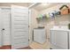 Convenient laundry room featuring modern washer and dryer units with overhead shelving at 364 Mossycup Dr, Fairburn, GA 30213