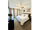 A cozy staged bedroom with white bedding, carpeted floors, and a ceiling fan at 3845 Pebble Beach Dr, Atlanta, GA 30349